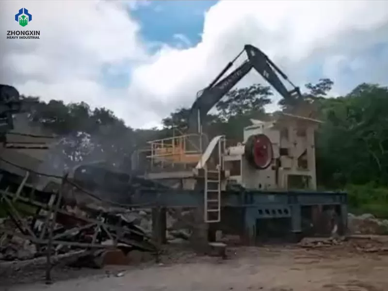 Planta móvil de mandíbula sobre neumáticos operando en cantera de granito.